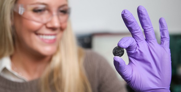 Anna Douglas holding one of the batteries that she has modified by adding millions of quantum dots made from iron pyrite, fool's gold. (John Russell / Vanderbilt)