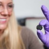Anna Douglas holding one of the batteries that she has modified by adding millions of quantum dots made from iron pyrite, fool's gold. (John Russell / Vanderbilt)